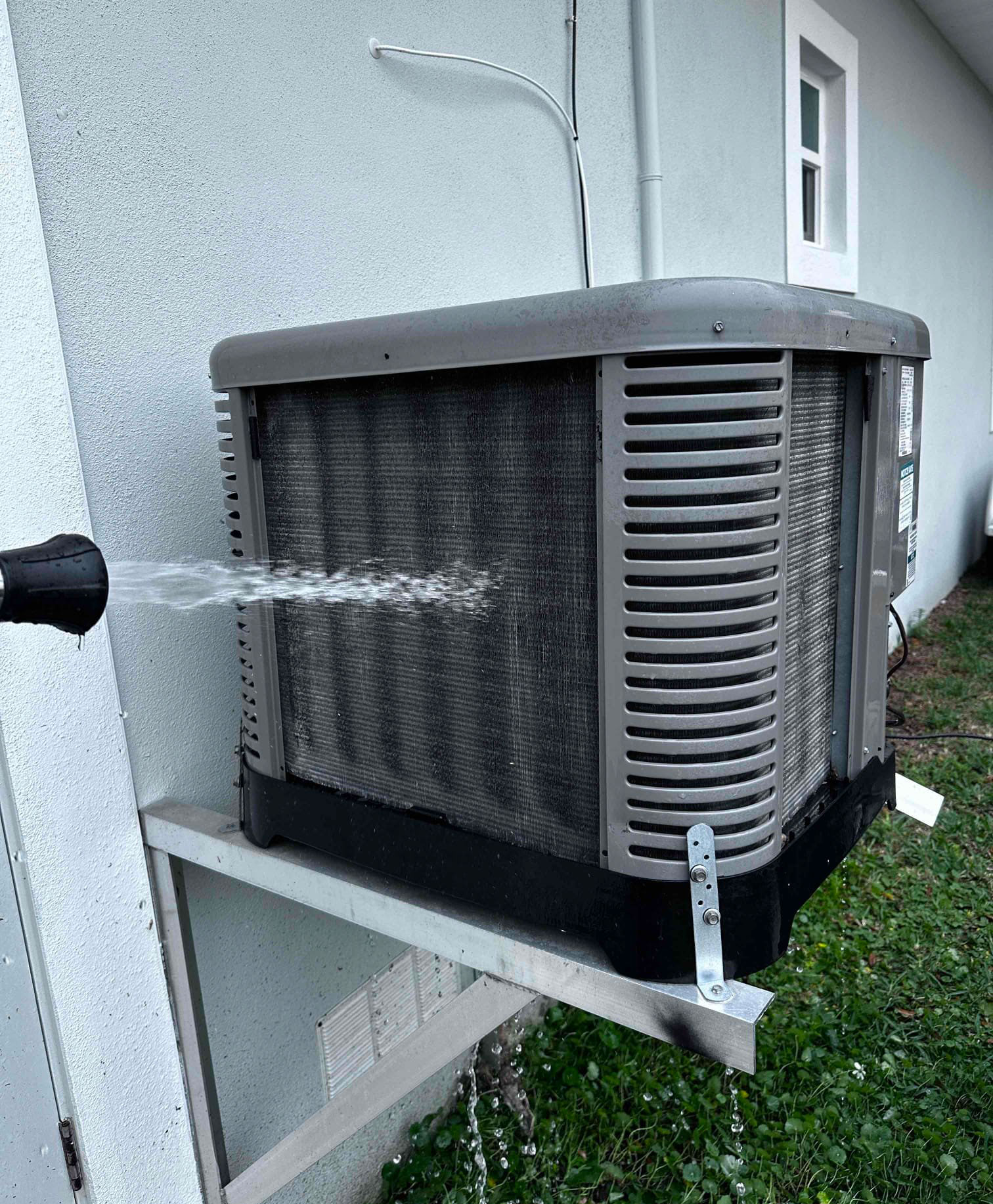 Cleaning an outdoor AC condenser coil with a hose