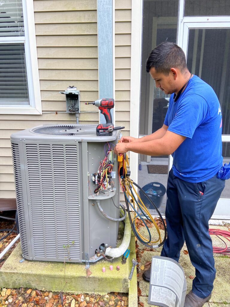 Alvarez Plumbing & AC technician repairing an outdoor AC condenser in Tampa