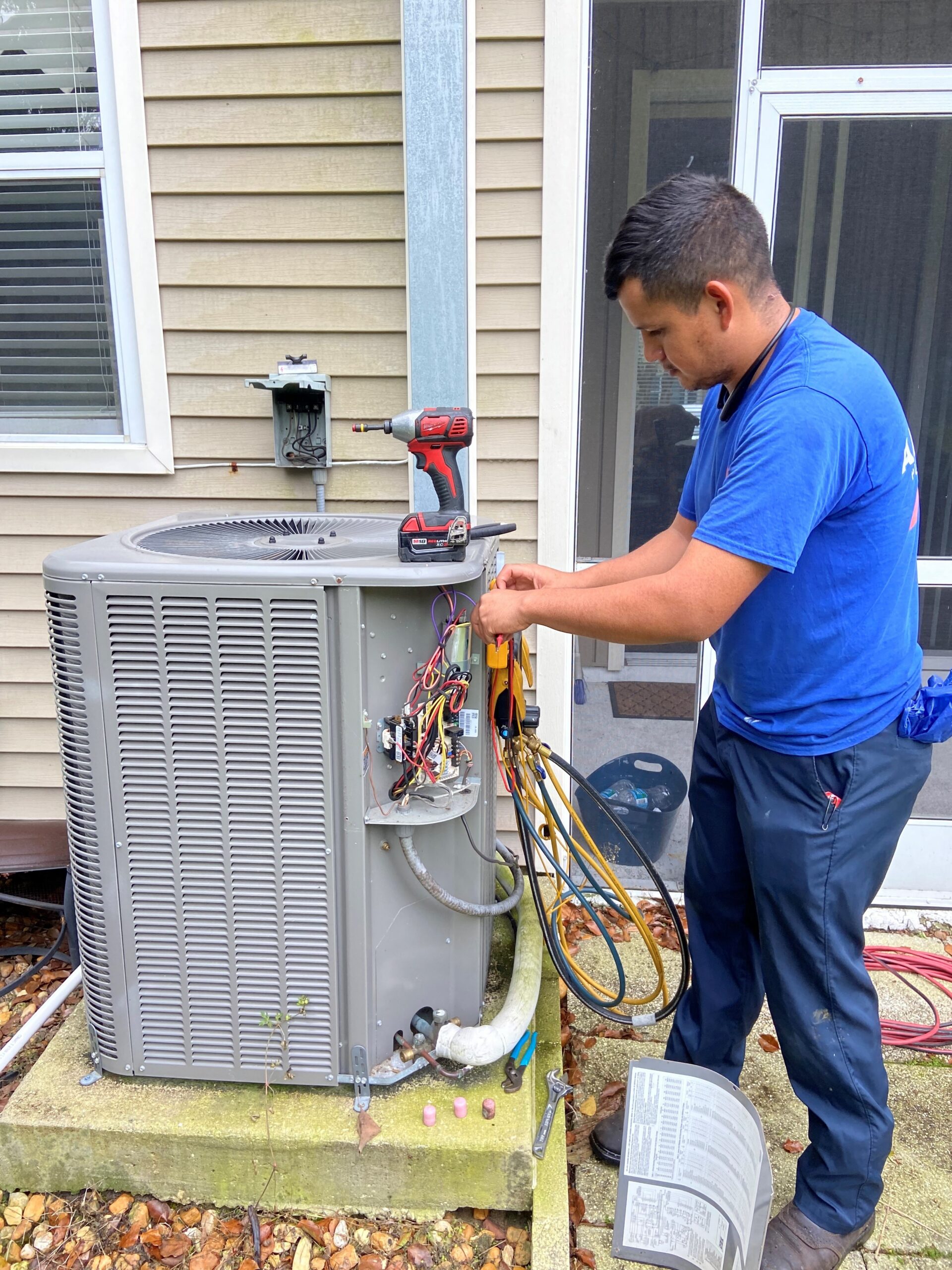 Alvarez Plumbing & AC technician repairing an outdoor AC condenser in Tampa