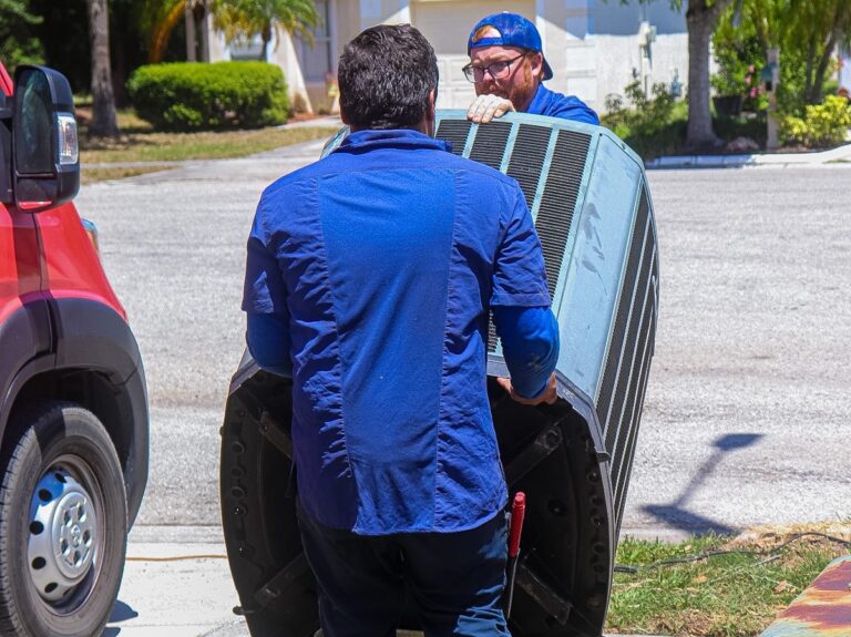 Alvarez Plumbing & AC technicians removing an old AC condenser during a Tampa AC replacement